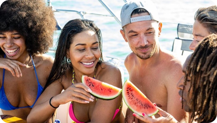 Friends enjoying watermelon on a boat